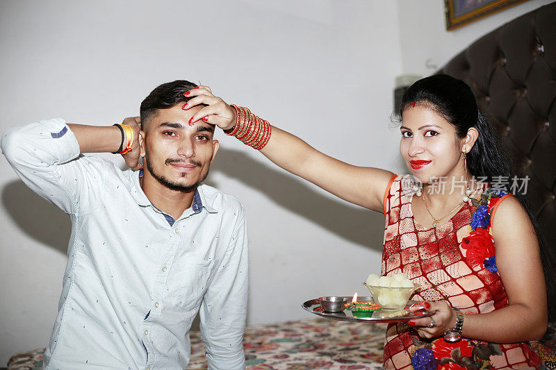 庆祝Bhai Dooj节或Raksha班丹，姐姐在哥哥额头上抹tikka